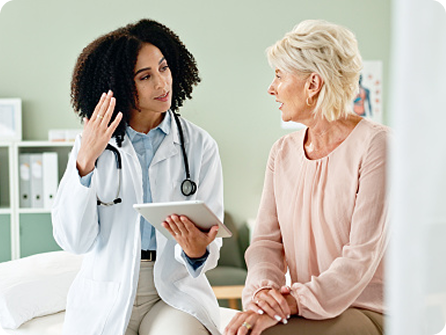 Doctor discussing with an older woman in a medical office.