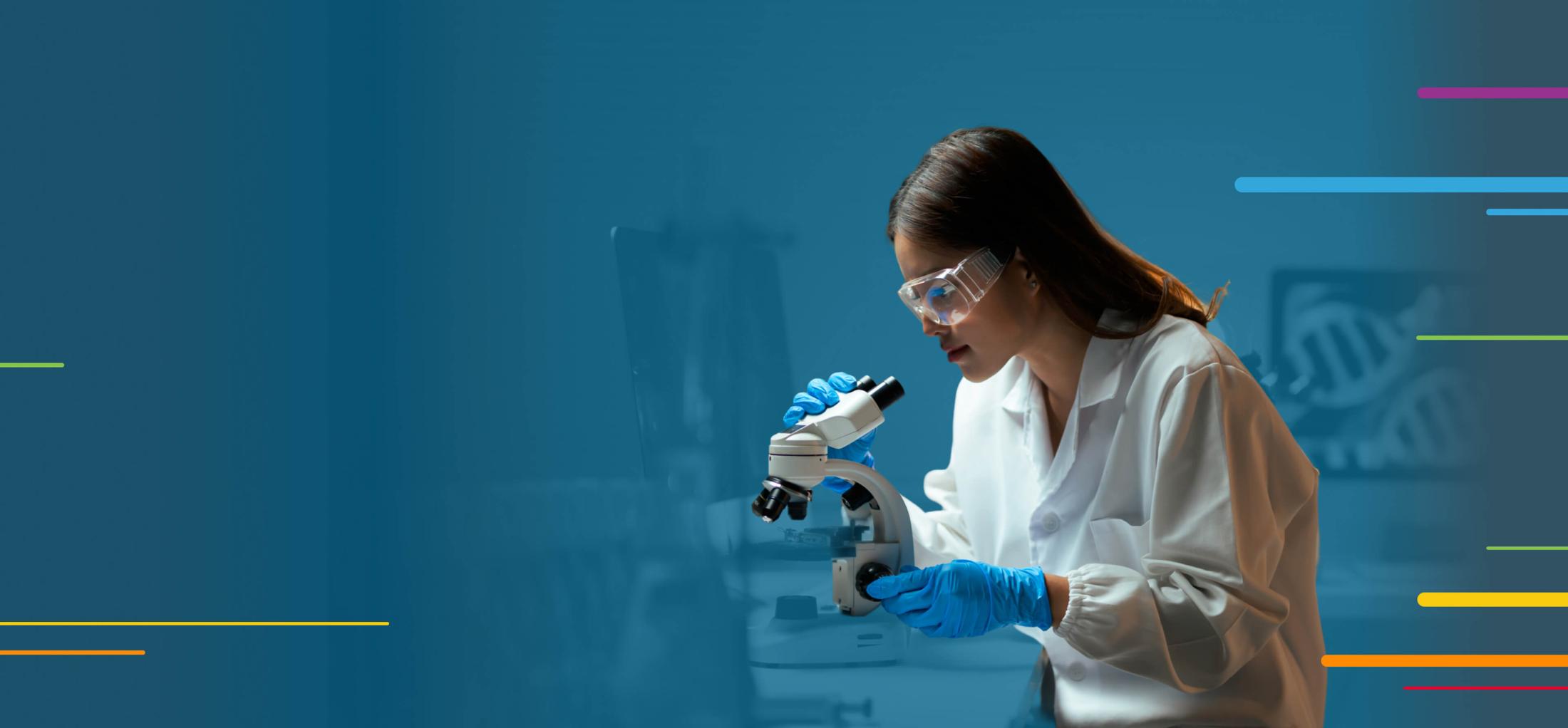 Scientist in lab coat and gloves examining a sample with a microscope.
